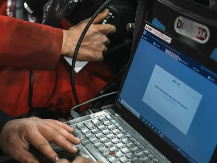 Diagnoză computerizată cu laptopul conectat la mașină